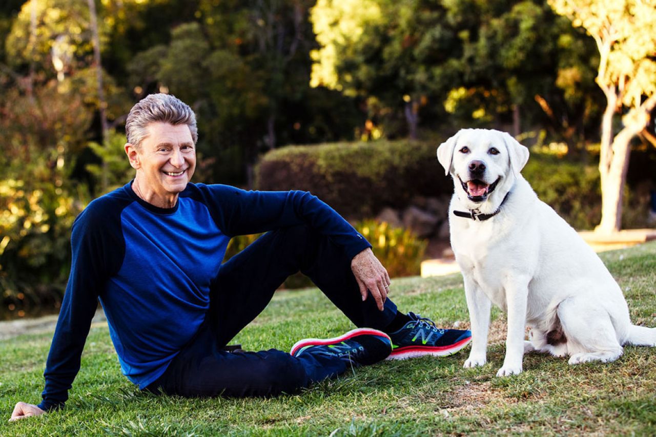 Paul Levine relaxing on his lawn with his dog