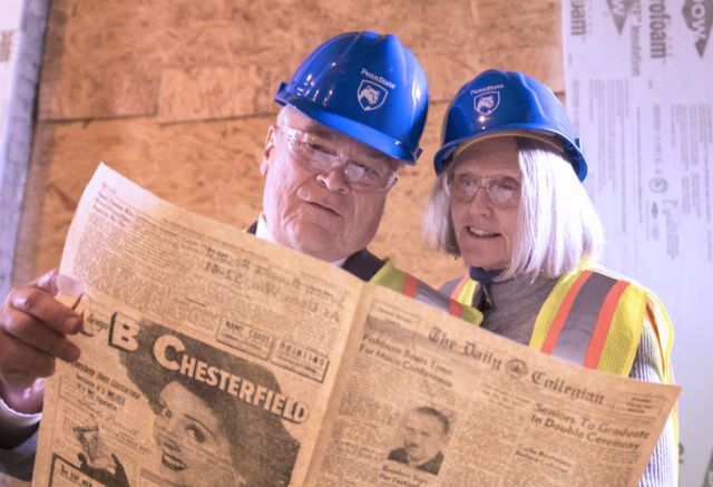 Penn State President Eric Barron and his wife Molly Barron scan through a Daily Collegian newspaper from March 3, 1949. The newspaper was one of many artifacts from 1949 pulled from a time capsule found in Willard Building during the current renovation and construction project. (Photo by Patrick Mansell)