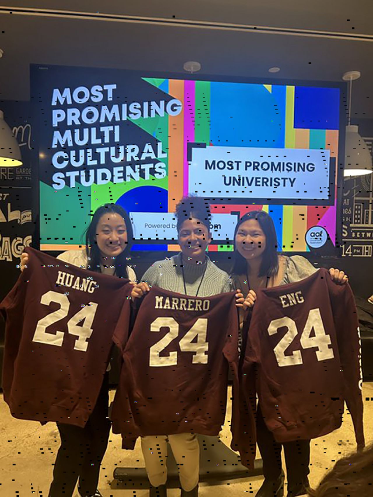 Three students holding No. 24 football jerseys