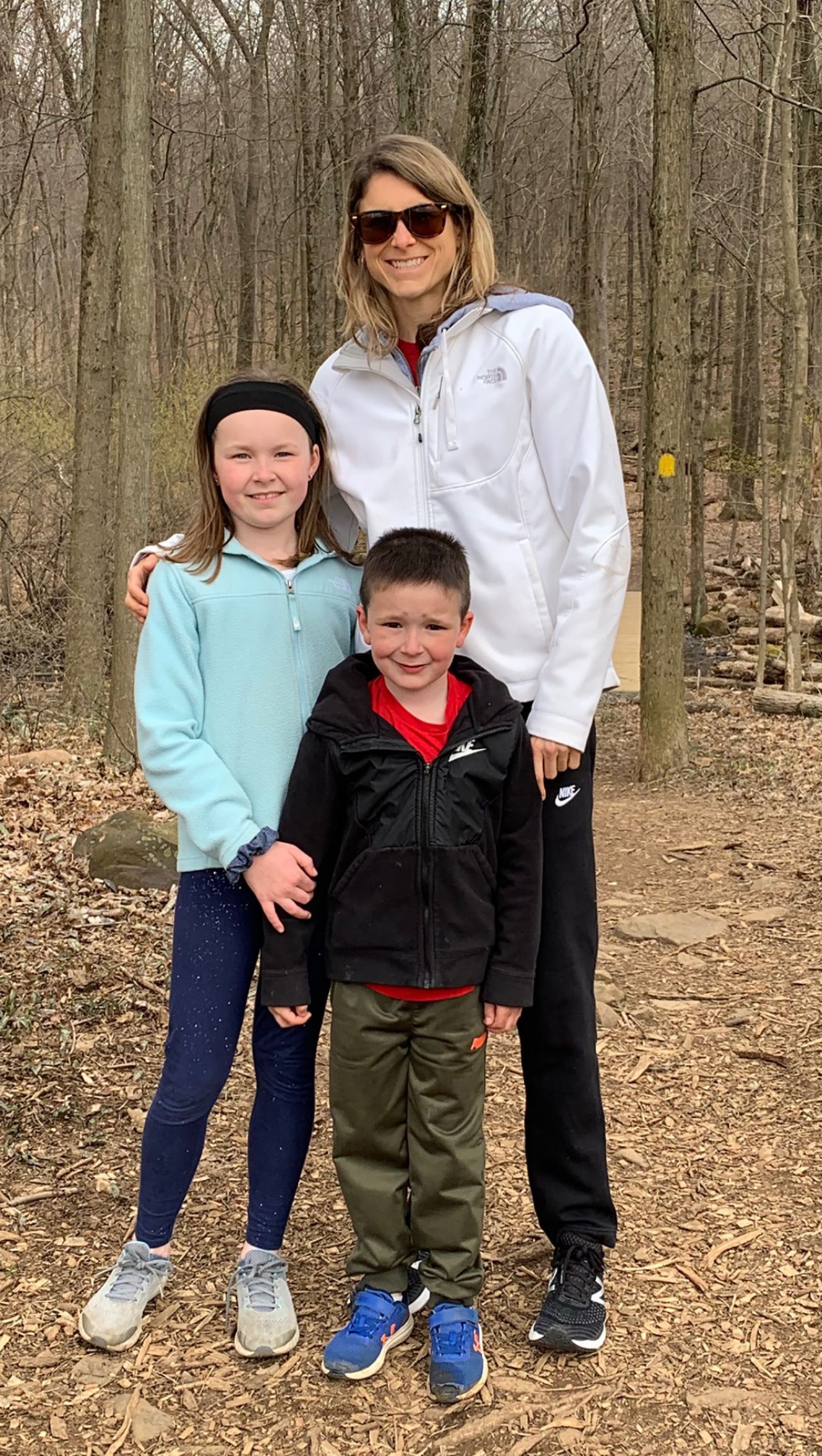 Amanda Gifford standing in the woods with her two children