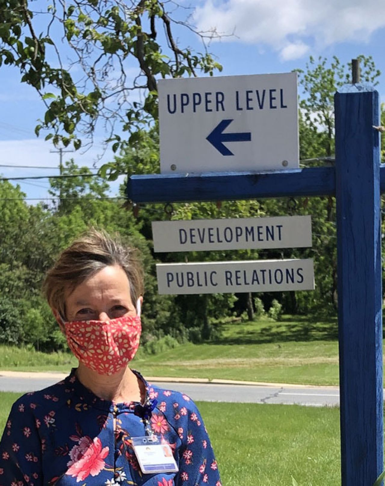 Photo of Cindy Stauffer near a directional sign to her office.