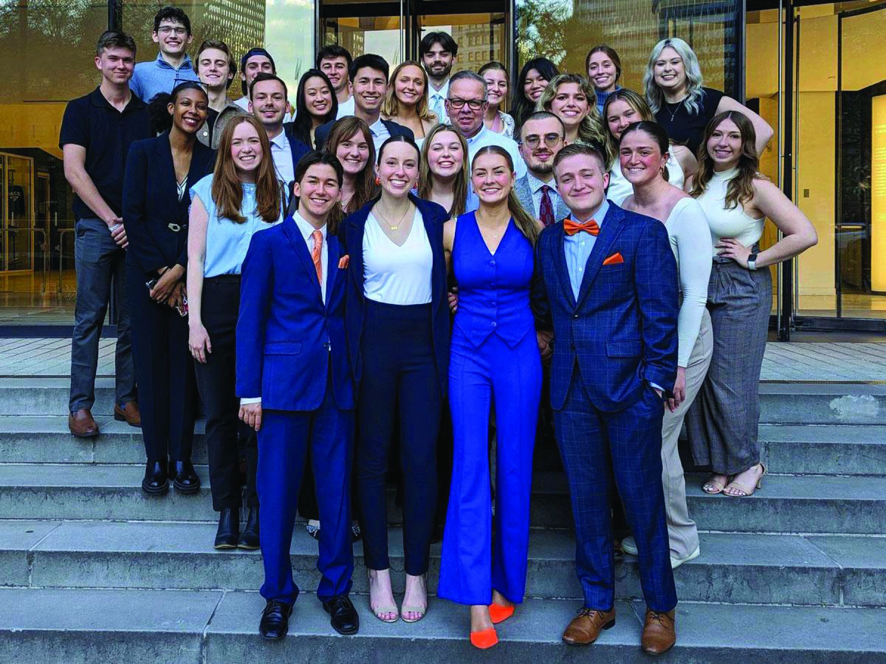 Group of well dressed students standing in rows on a set of steps