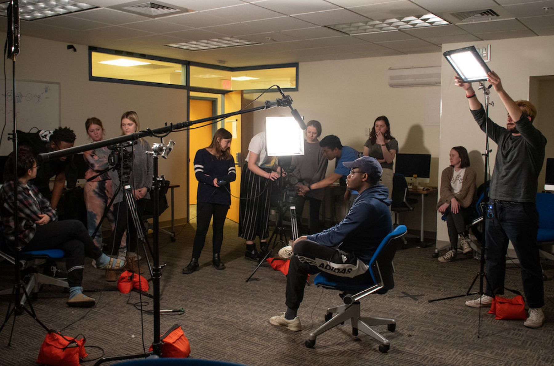 CommAgency students on set with lights and camera for a shoot.