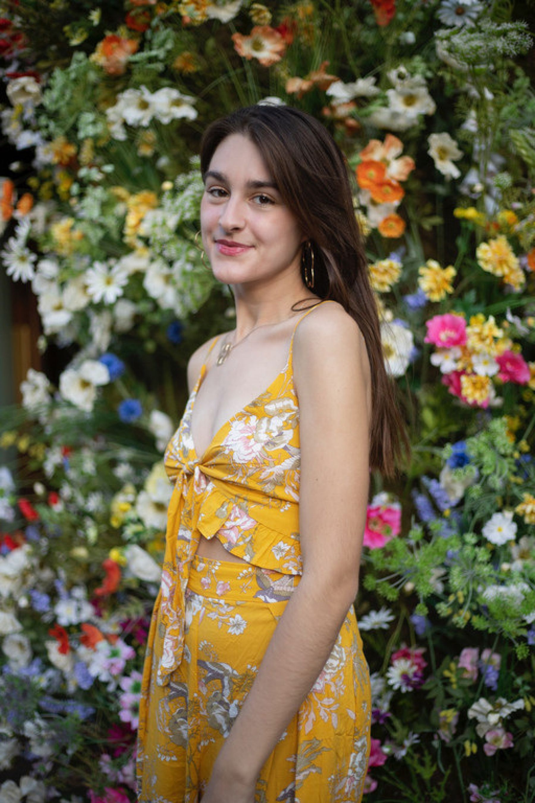 Portrait of Jordan Pietrafitta in a dress amidst some flowers.