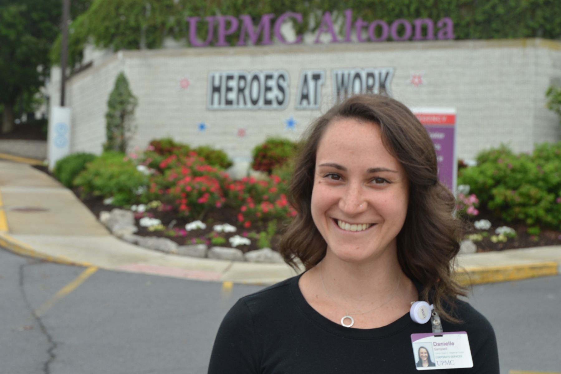 Danielle Sampsell stands in front of the hospital on a sunny day.