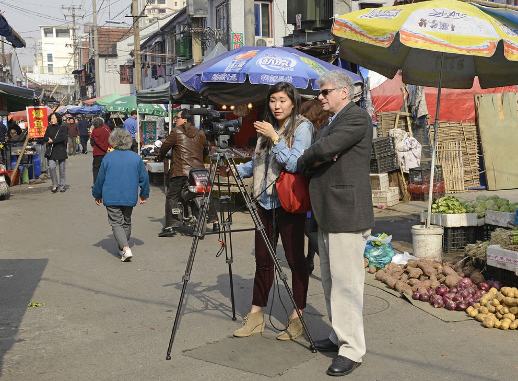 Tony Barbieri and a student on the street reporting with a camera in China.