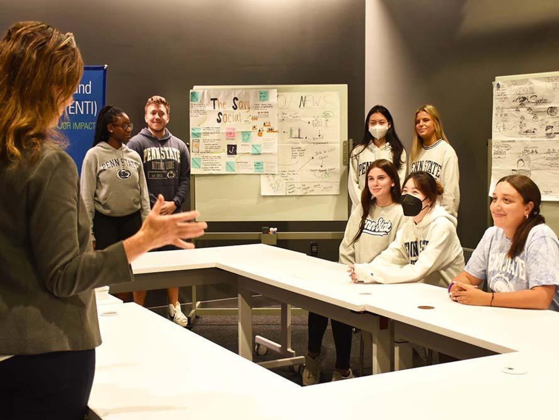 Students gathered around an open table talking to their faculty member