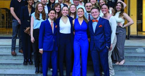 Group of well dressed students standing in rows on a set of steps