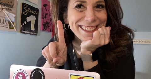 Podcaster and alumna Michelle Kinsman in her office with her laptop